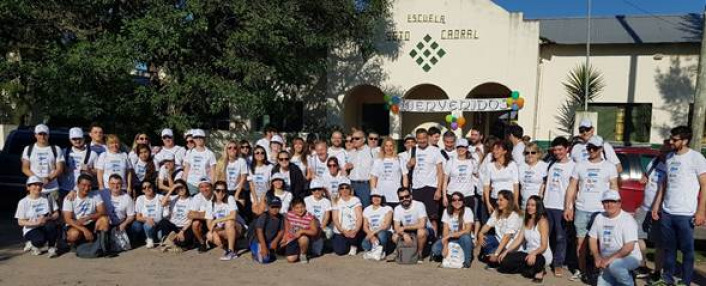 El secretario general de CAME, José A. Bereciartúa, junto a voluntarios acondicionando juegos de la escuela Sargento Cabral